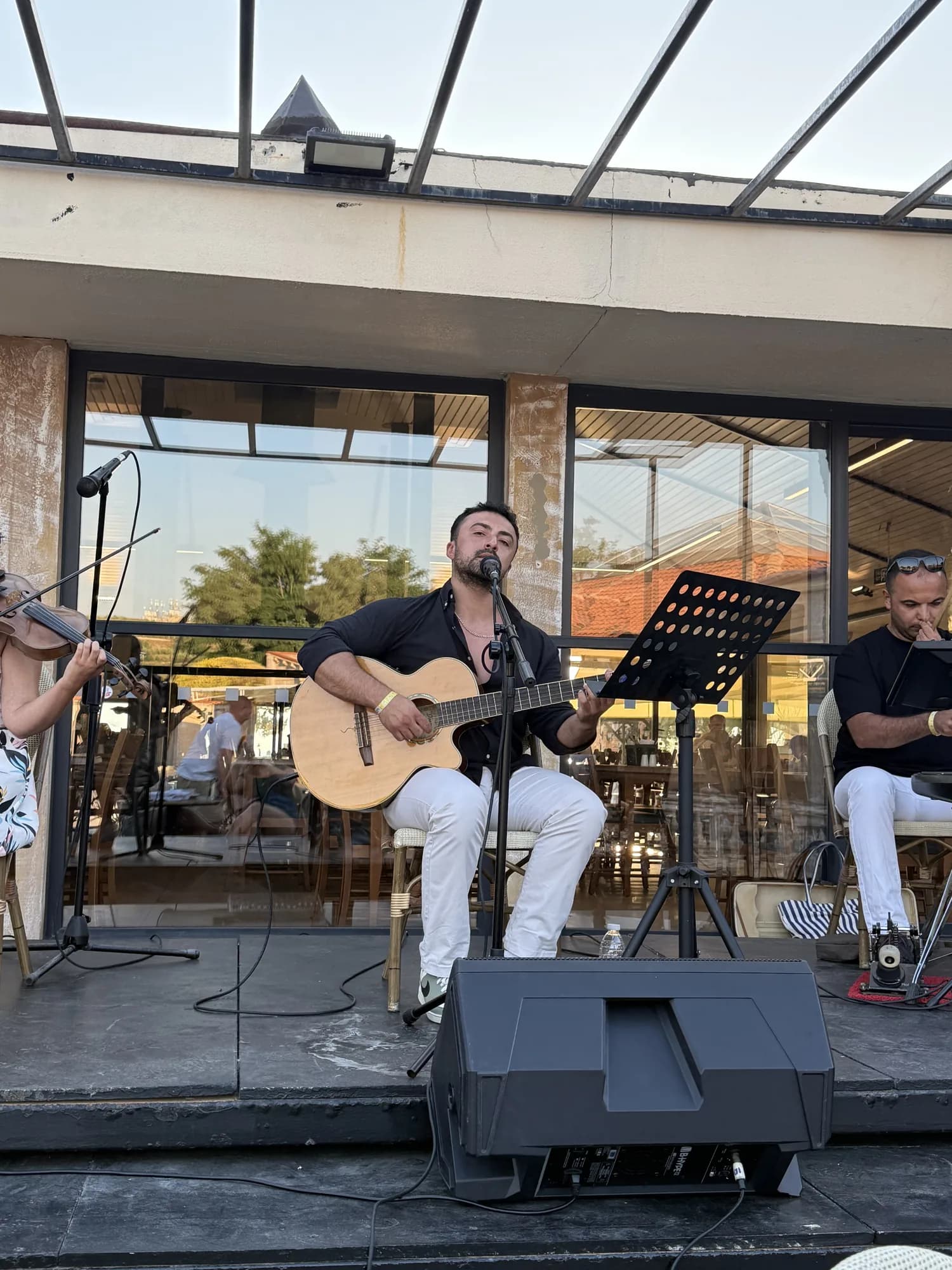 Yağız Cem Yılmaz açık hava sahnesinde gitar çalıp şarkı söylerken