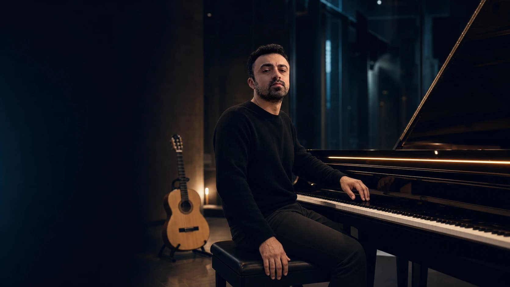 Yağız Cem Yılmaz, karanlık bir müzik stüdyosunda piyano başında; arka planda klasik gitar