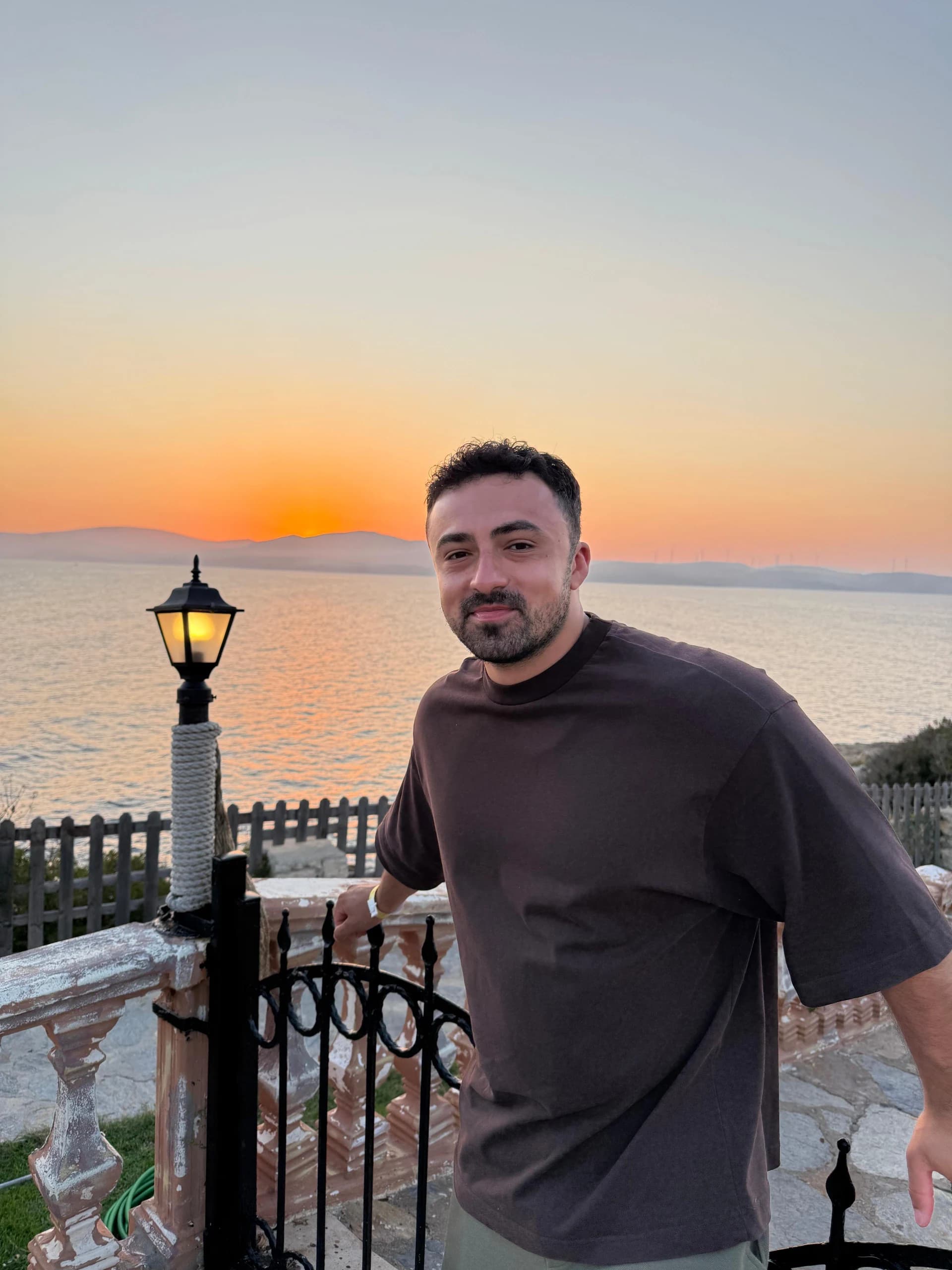 Yağız Cem Yılmaz, gün batımında deniz kıyısında